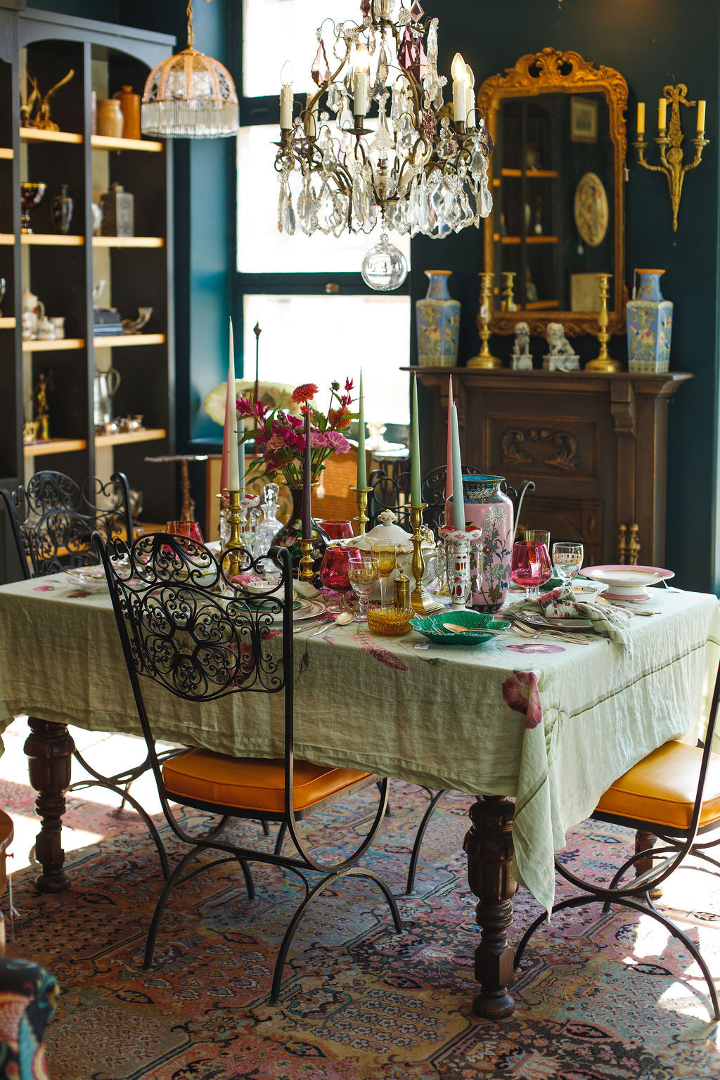 Dining room with ornate furniture, chandelier, and decorative items on a table.